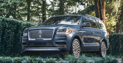 Lincoln SUV parked in a driveway with hedges surrounding it