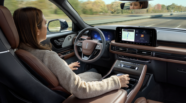 A woman is seen sitting in the driver’s seat of her 2025 Lincoln Aviator® SUV with her hands off the steering wheel. | Planet Lincoln Love Field in Dallas TX