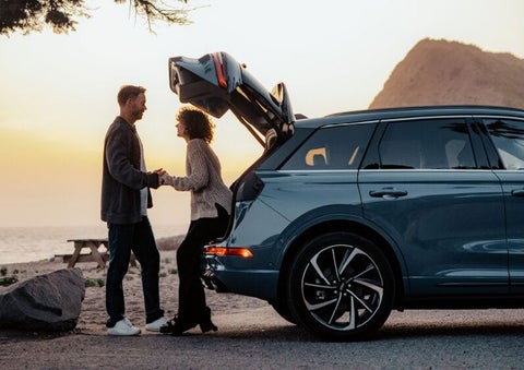 A couple share a moment together outside a 2025 Lincoln Corsair® SUV near the open liftgate. | Planet Lincoln Love Field in Dallas TX
