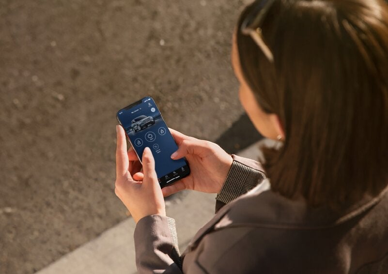 A person is shown interacting with a smartphone to connect to a Lincoln vehicle via the Lincoln Way® App. | Planet Lincoln Love Field in Dallas TX