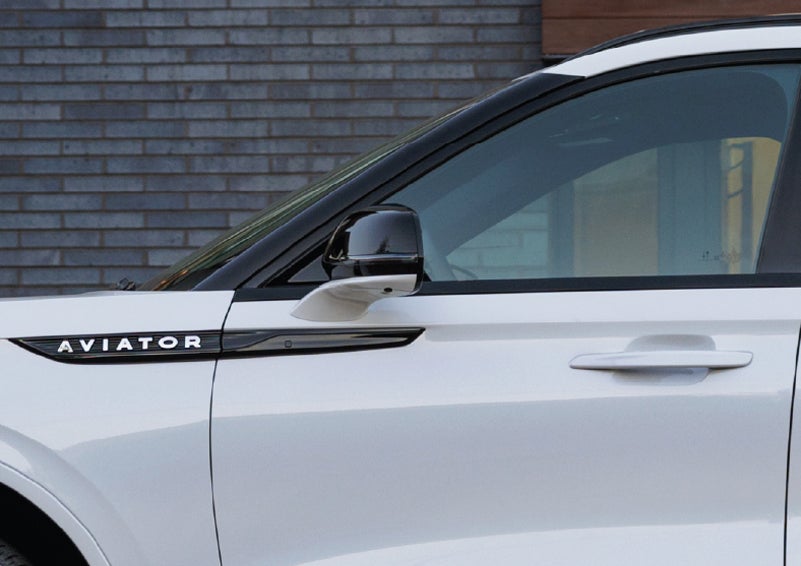 The driver’s side door and fender badging of a white 2026 Lincoln Aviator® SUV are showcased. | Planet Lincoln Love Field in Dallas TX