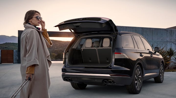 A woman approaches a 2026 Lincoln Aviator® SUV with its rear liftgate open. | Planet Lincoln Love Field in Dallas TX