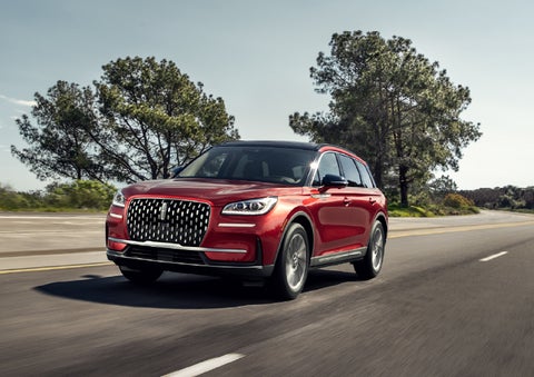 A 2026 Lincoln Corsair® SUV is shown being driven on a country road. | Planet Lincoln Love Field in Dallas TX