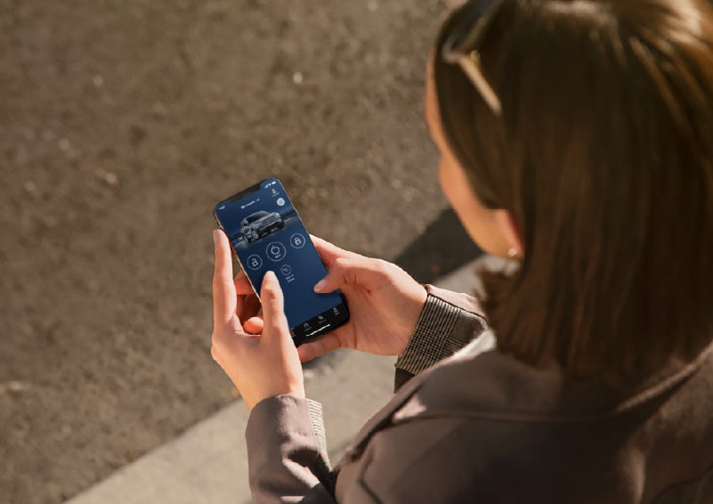 A person is shown interacting with a smartphone to connect to a Lincoln vehicle via the Lincoln Way® app. | Planet Lincoln Love Field in Dallas TX