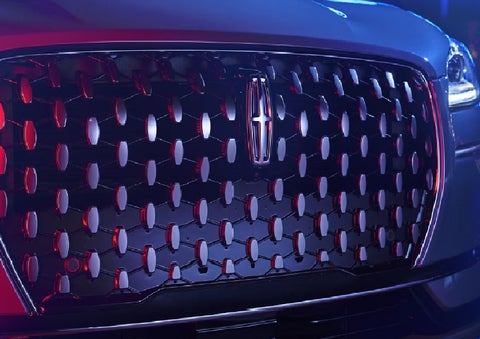 The grille of a 2025 Lincoln Corsair&reg; SUV reflects neon light at night. | Planet Lincoln Love Field in Dallas TX