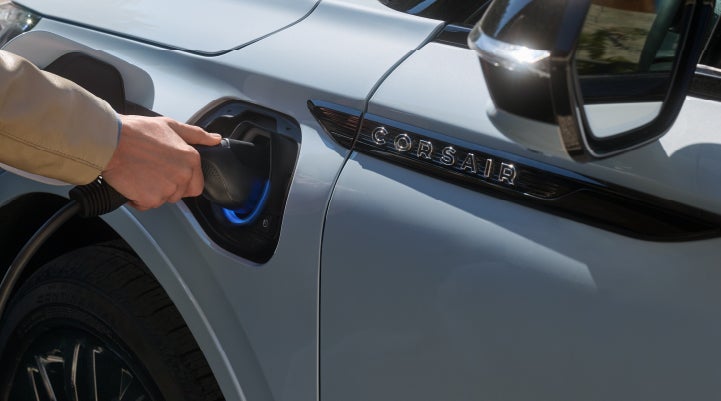 A hand is plugging in a 2026 Lincoln Corsair® Grand Touring Plug-in Hybrid SUV. | Planet Lincoln Love Field in Dallas TX