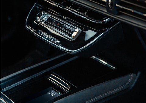 A smartphone rests on the available wireless charging pad in the front center console cubby | Planet Lincoln Love Field in Dallas TX