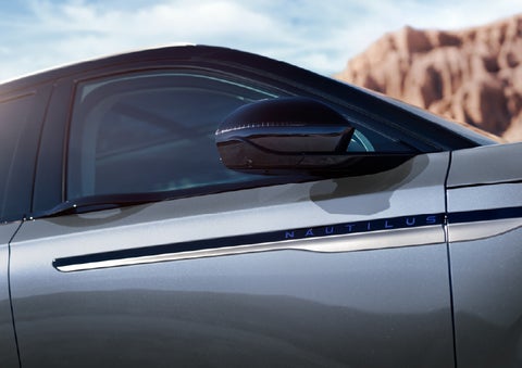 Blue lettering on the side of the vehicle that reads Nautilus indicates the available Hybrid Powertrain. | Planet Lincoln Love Field in Dallas TX