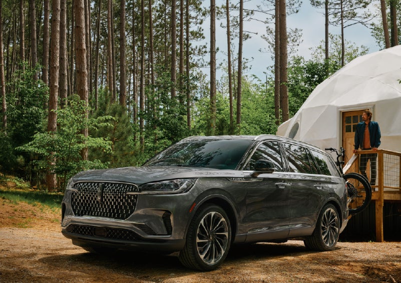 A 2027 Lincoln Aviator® is parked next to a high end glamping site. | Planet Lincoln Love Field in Dallas TX