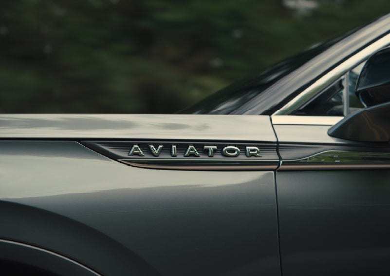 The driver’s side door and fender badging of a gray 2027 Lincoln Aviator® SUV are showcased. | Planet Lincoln Love Field in Dallas TX